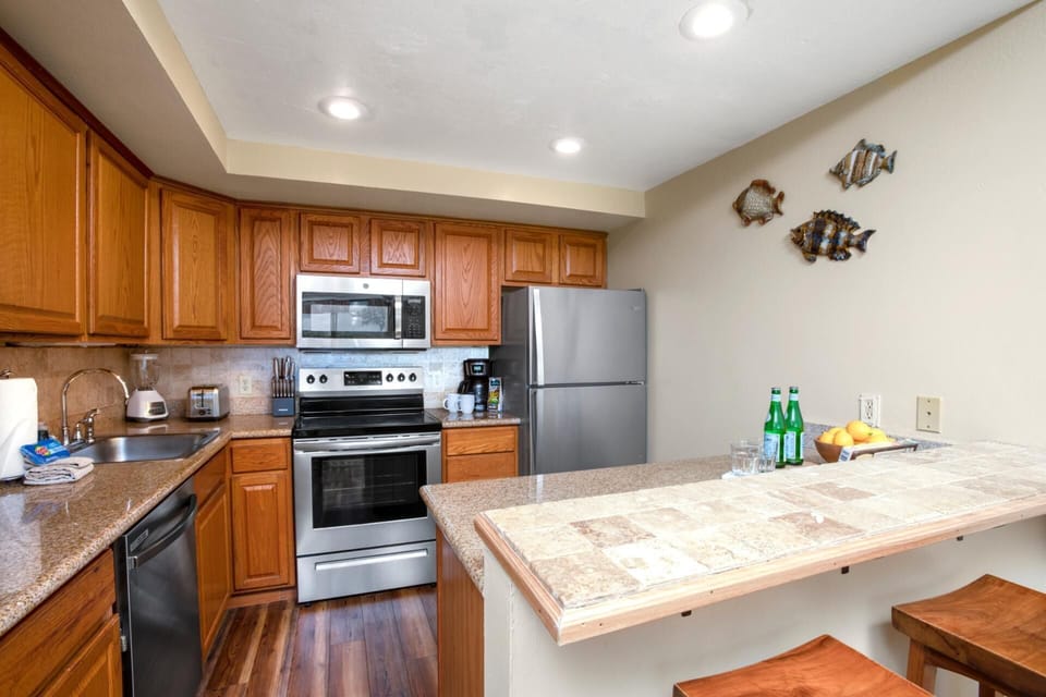 Cozy and well-equipped, this kitchen features warm wood cabinetry, modern appliances, and a relaxed island bar   