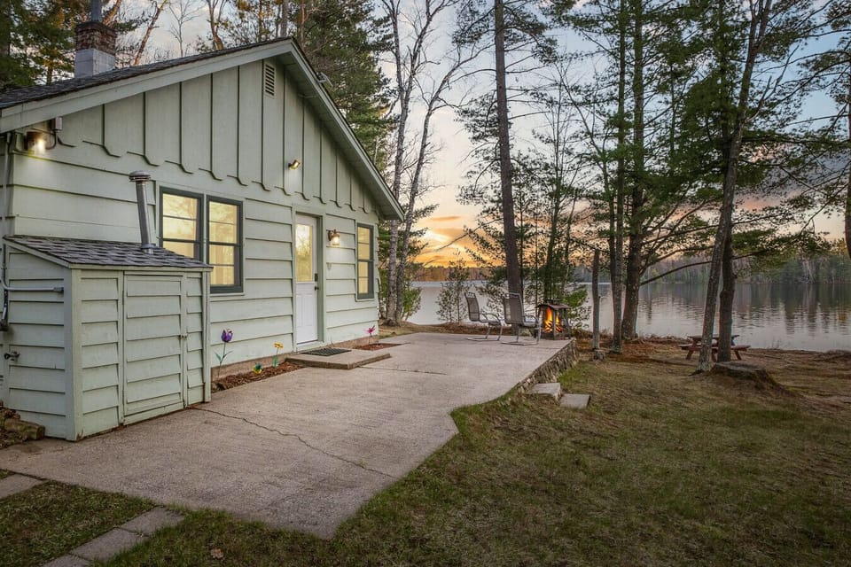 Unwind on the cottage patio with lake views and a cozy fire pit—just steps from the shoreline