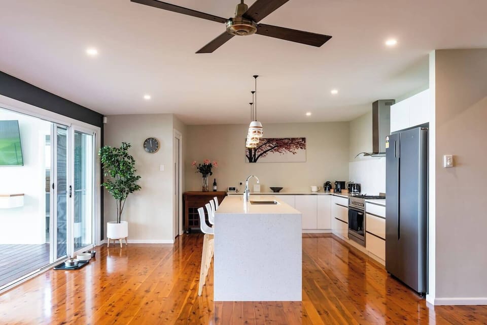 A fully-equipped kitchen features a five-burner gas stovetop, large double fridge, spacious oven and loads of bench space.