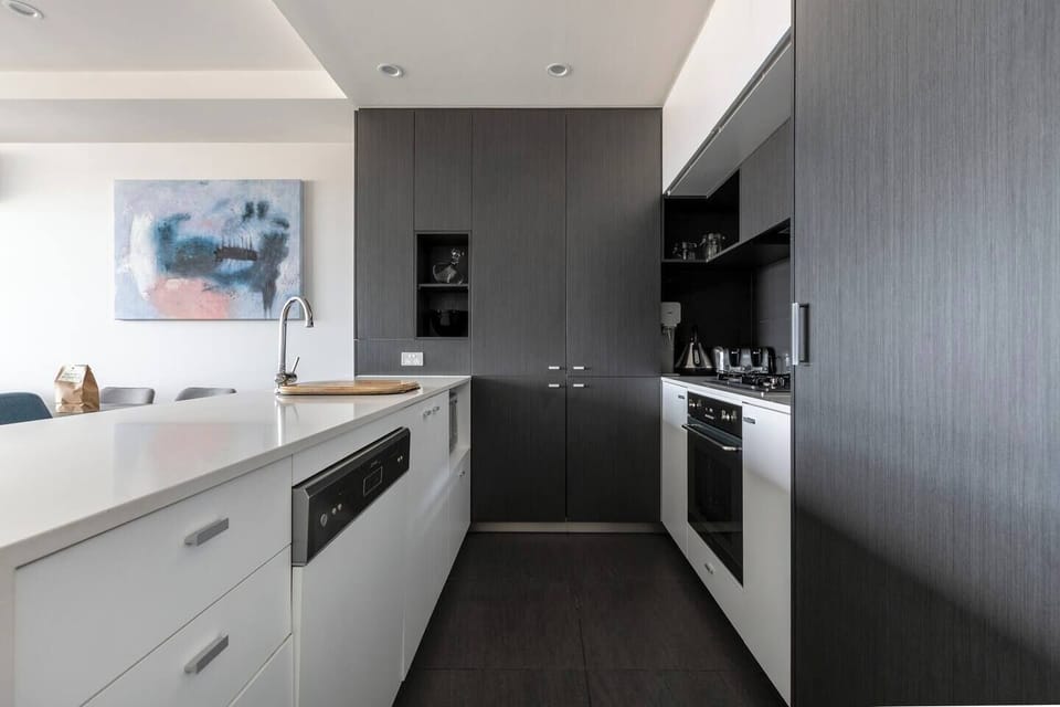 A fully-equipped kitchen has marble benchtops and all the modern appliances including a dishwasher, gas cooktop, oven and a full-sized fridge