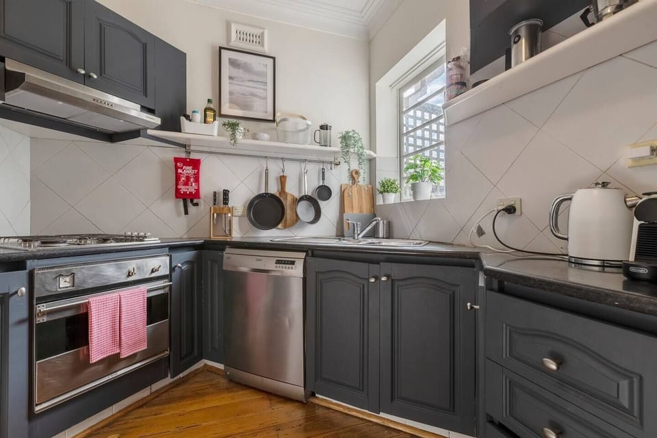  This corner kitchen is brightly lit with natural light thanks to the large window in the corner.
