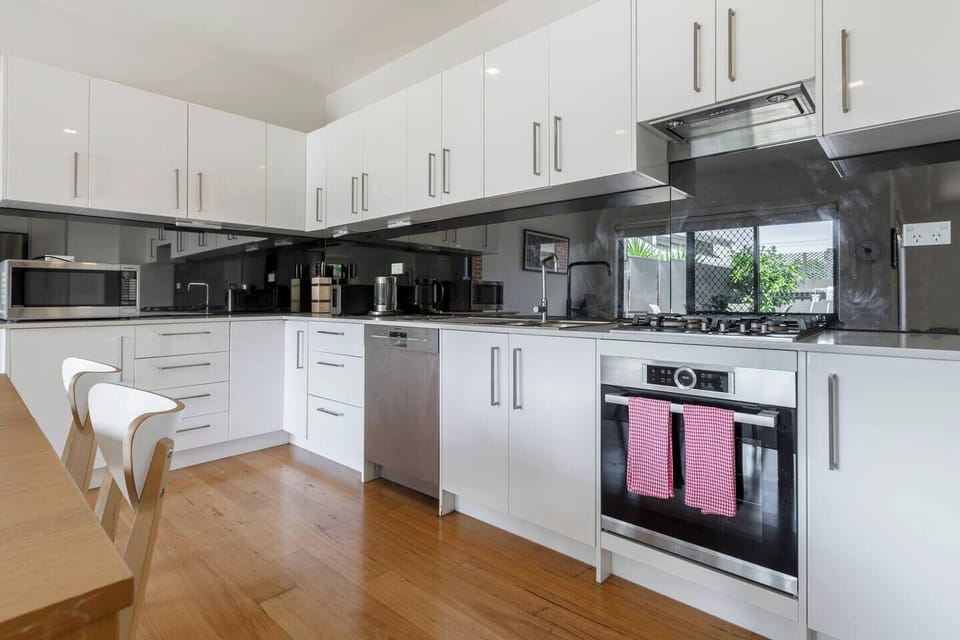 A fully-equipped kitchen is stocked with all basic necessities and fitted with a gas cooktop, microwave, dishwasher, oven and a full-sized fridge