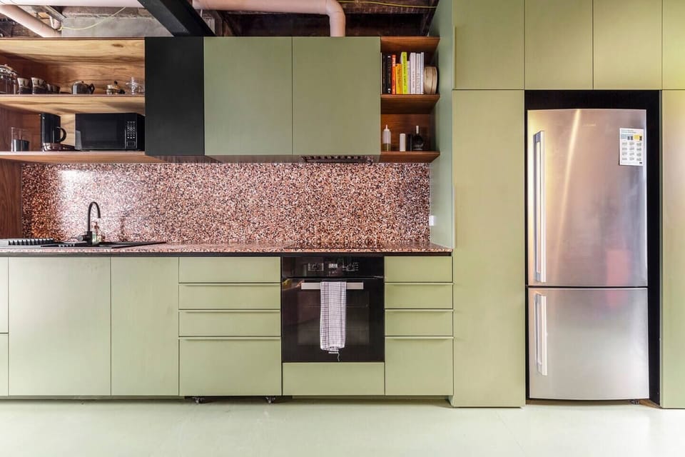 The kitchen features open shelving, stunning terrazzo tiling space, recycled Eucalyptus open shelving and sleek timber cabinets.
