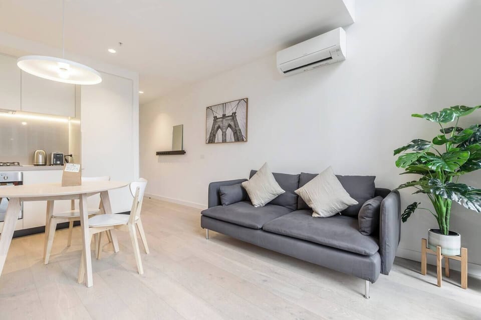 Bright, open-plan living means the lounge room sits alongside an indoor dining space with a wooden table for two