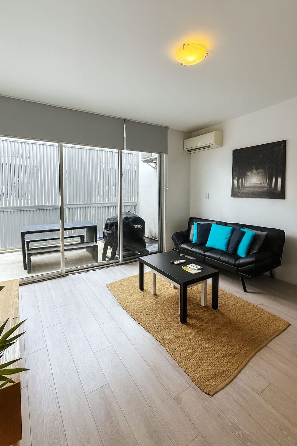 The living room extends to a generous sunlit terrace with a BBQ and outdoor dining table for alfresco meals. 