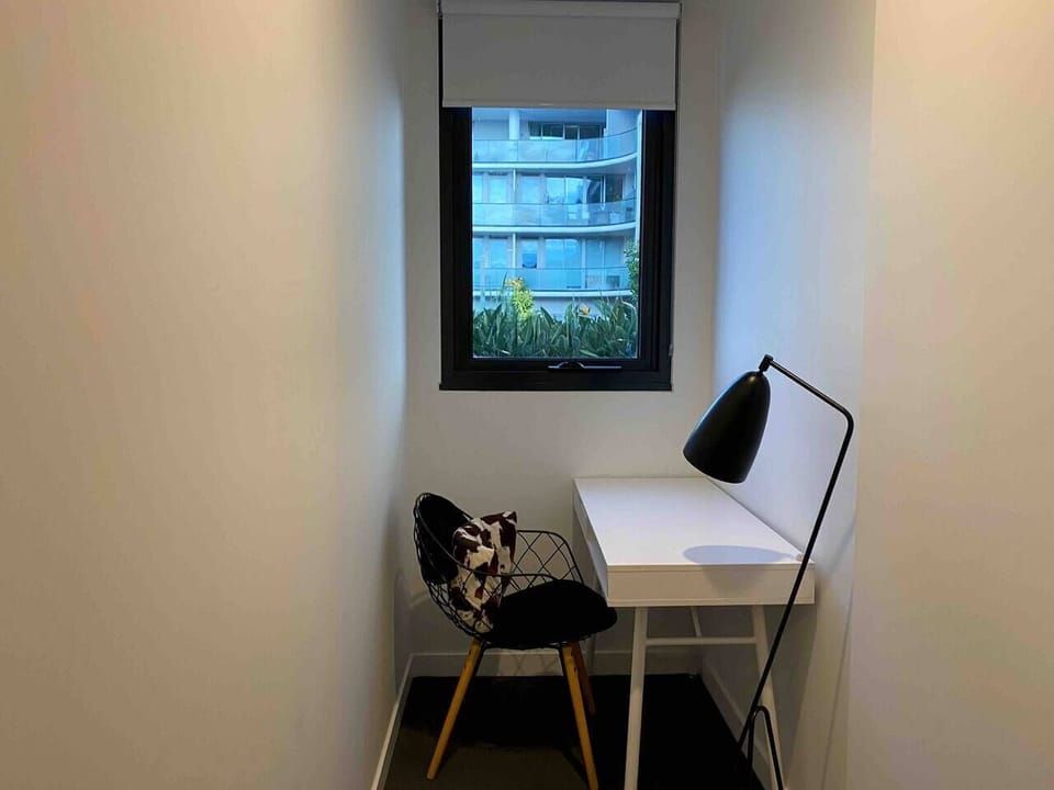 Settle into this quiet study nook, where a dedicated desk and soft natural light create a calm space to focus or catch up on work.