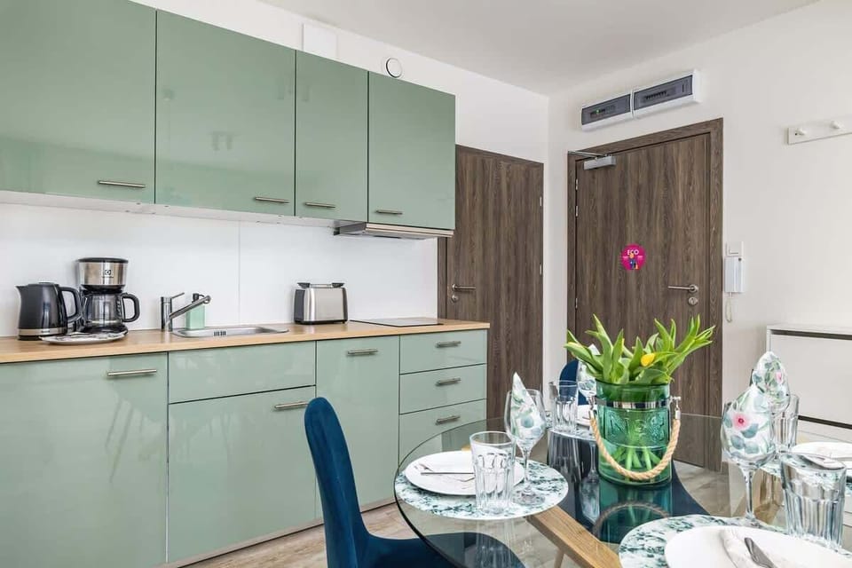 A dining area with a round table set for two and floral decorations.


