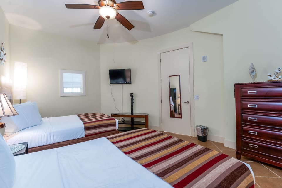 Your guests can unwind in our matching beds with luxury triple sheeting, unpack in our large dresser, and relax with a show on our mounted TV. Our guest room is perfect for your travel companions.