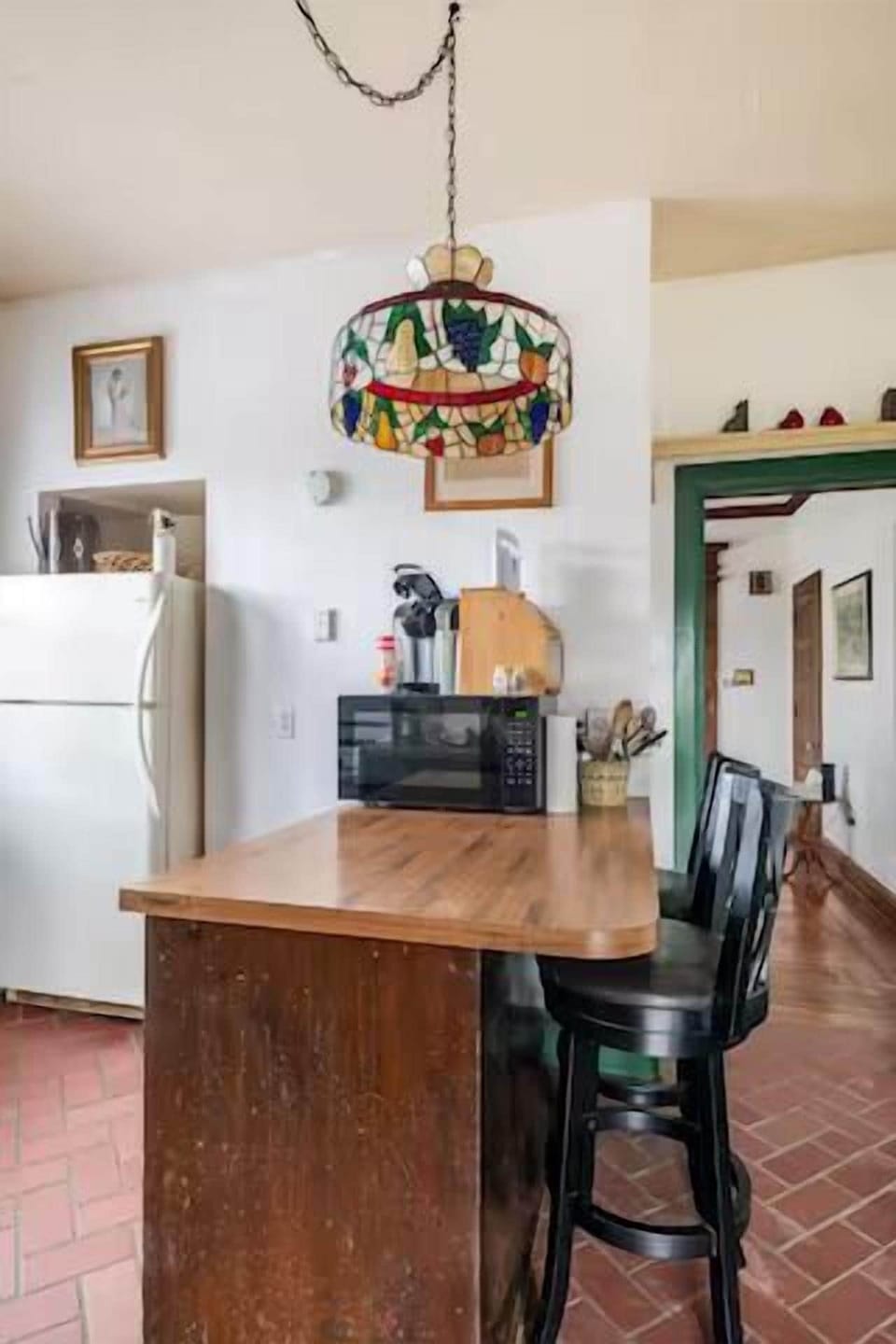 Charming Kitchen Nook: Enjoy meals under a colorful stained glass light and warm inviting vibes!