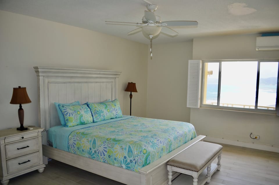 Large bedroom with king sized bed and split AC unit.