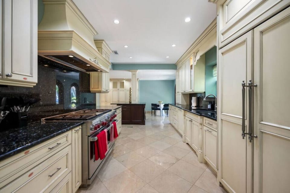This kitchen is a chef's dream, featuring top-of-the-line appliances like an oven, stove, microwave, and coffee maker, all complemented by classic cabinets that enhance the elegant design.