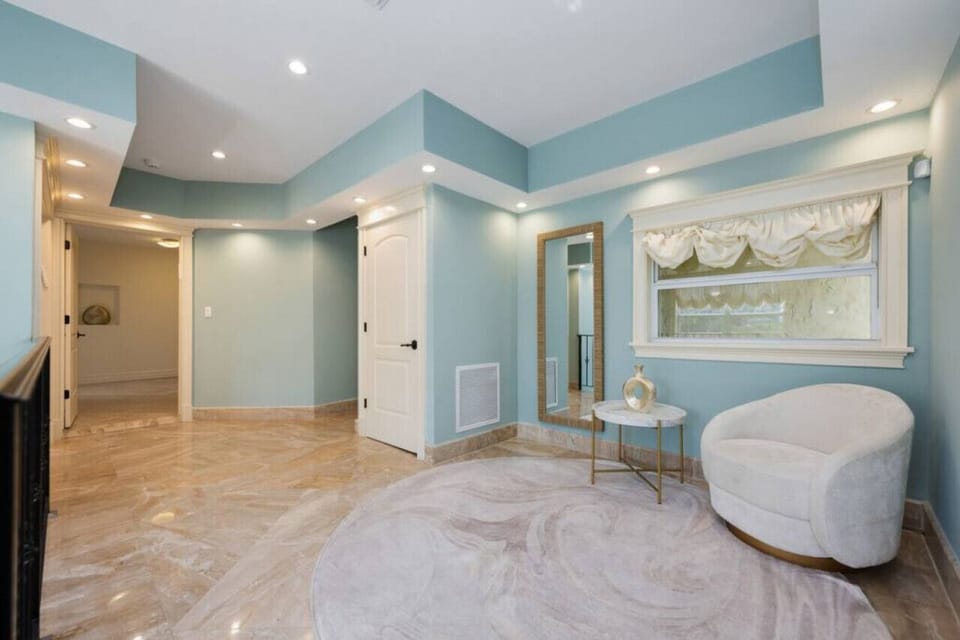 This spacious room has elegant marble floors, and a plush lounge chair.