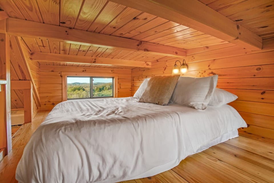 Cozy cabin loft with a bed and scenic window view