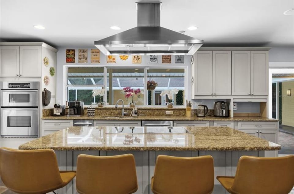 Open kitchen with bar and stools facing the pool area