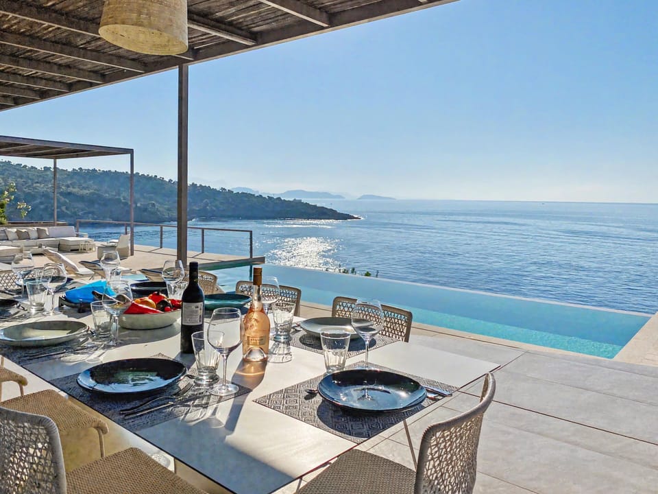 Dine al fresco by the stunning infinity pool, overlooking the sparkling sea.