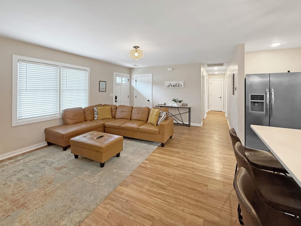 Bright open living with leather sectional and breakfast bar