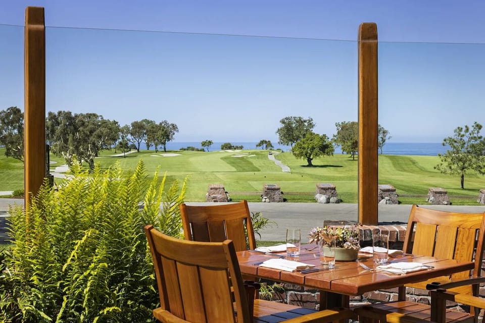 Savor al fresco meals with sweeping fairway and ocean views.