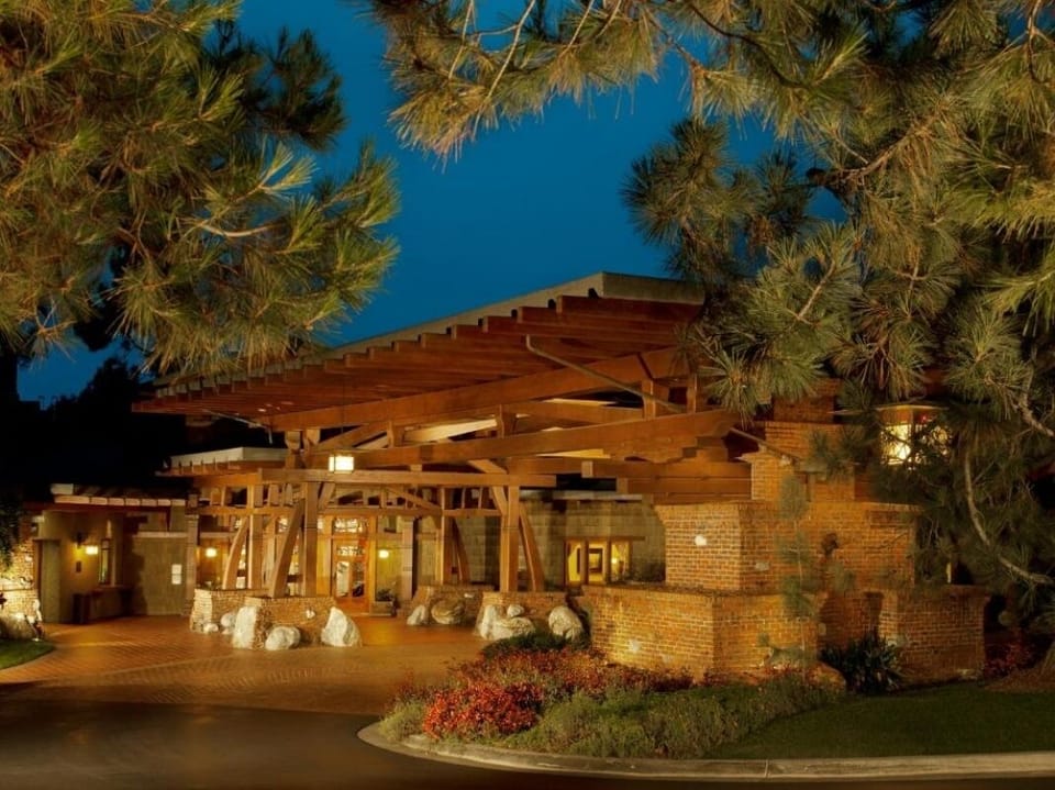 Arrive to a warmly lit entrance framed by tranquil pines.