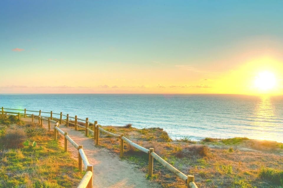 Stroll golden paths to the sea as sunlight fades.