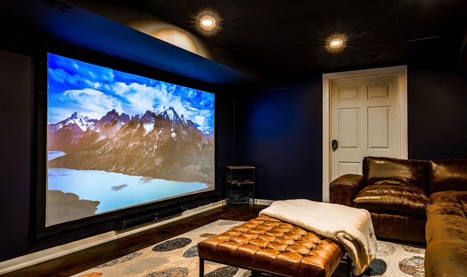 The Retreat: 120" of life-size movie experience.  Projector is ready to plug/play.   Serious speakers, set up to round out the immersive experience.  Host a showing from your phone, or choose Youtube TV, Netflix, etc. This theatre is the room my family has always wanted!