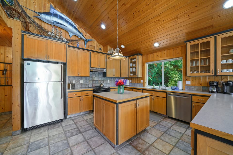 Upstairs fully stocked kitchen with island and breakfast bar, open to  living room with Cable TV, gas fireplace, 2 sleeper sofas and dining area. Access to front deck with BBQ.