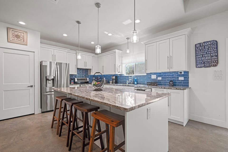 A kitchen with a large island, ample counter space, and stainless steel appliances.