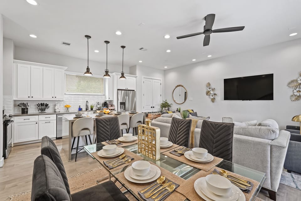 Dining area with set table opens to modern kitchen and cozy living room seating