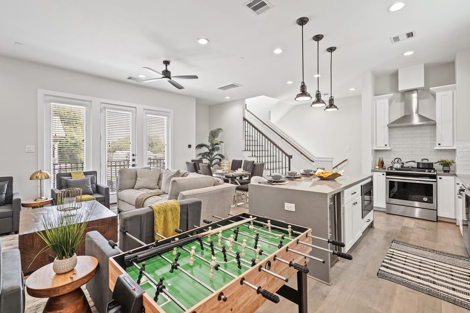 Spacious open kitchen and living area with foosball table, seating, and decor.