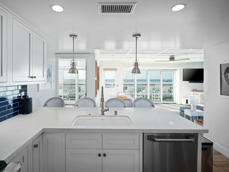 This fully equipped open-plan kitchen boasts a modern design, sleek countertops, and a stylish bar with stools for casual dining.