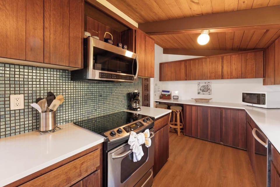 Inviting kitchen featuring stainless steel appliances and elegant wood cabinetry, bringing a cozy ambiance to this island home.