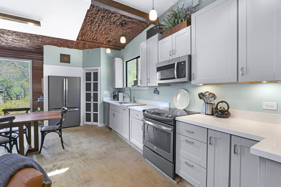 The kitchen is fully stocked with stainless steel appliances