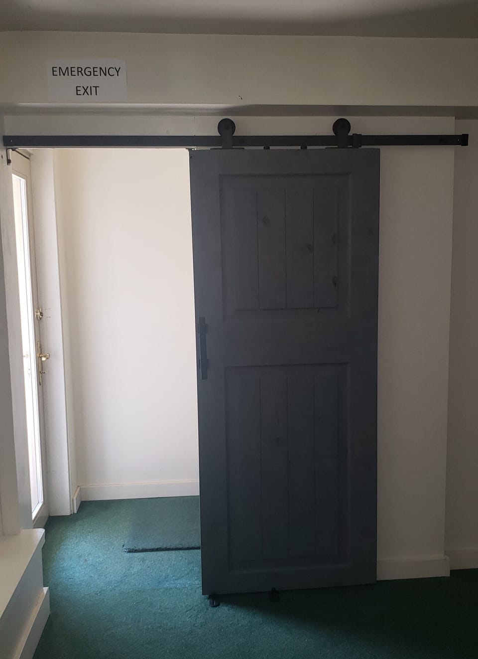 Sliding barn door leads to 2nd entrance to outdoors.