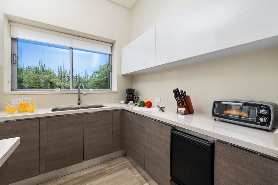 Step into the heart of the villa, where the open design seamlessly integrates the living room, dining space, and fully equipped kitchen.