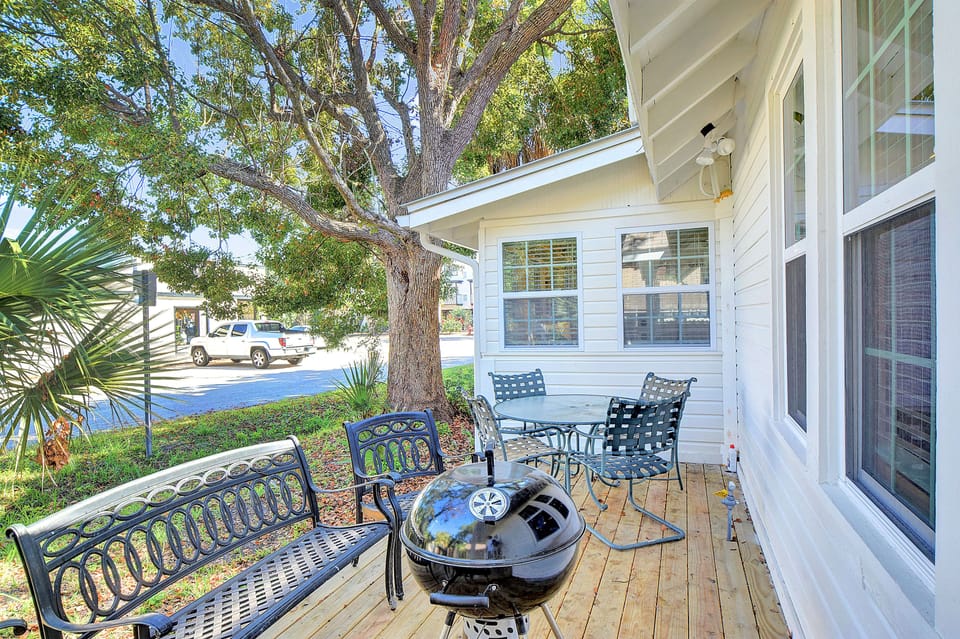 Grill and Outdoor Seating Area – The Stumble Home - Savor coastal breezes—and bring your pup along—on the back deck at The Stumble Home, complete with a charcoal grill and shaded seating after a day of beachside adventures.