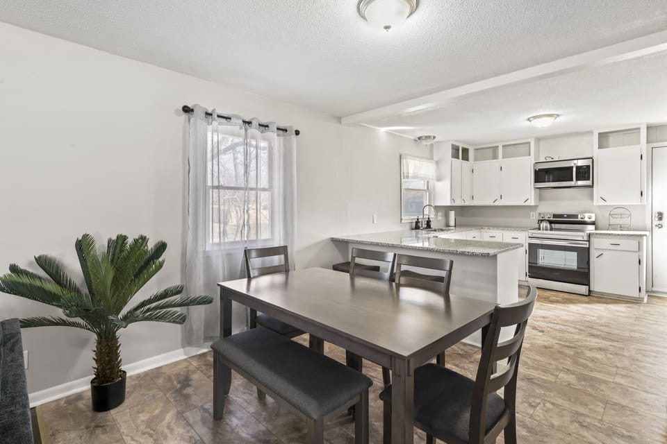 Dining area, seating for 6 at table, 2 more at countertop with barstools