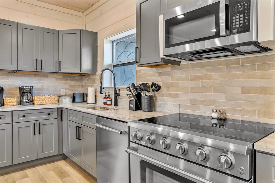 Fully equipped chef’s kitchen with granite countertops and bar seating.