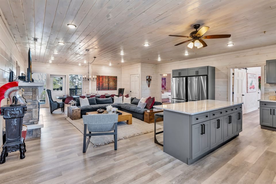 Open concept living area featuring a fireplace and large TV. 