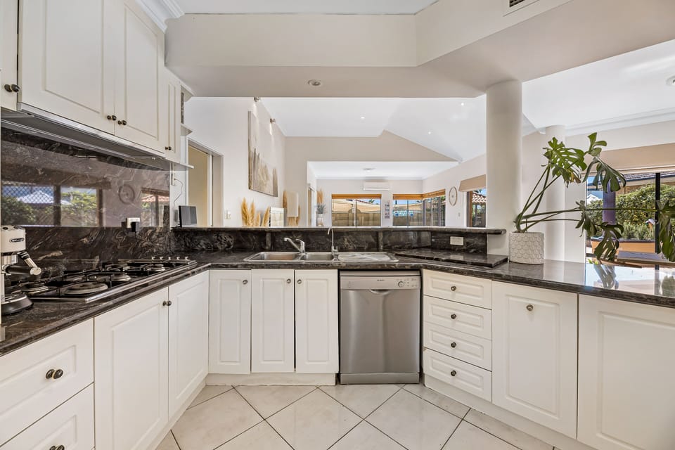 The gourmet kitchen is a chef's dream, with sleek countertops, high-end appliances, and plenty of storage space.