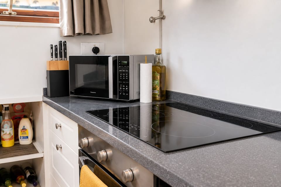 Induction hob, oven, and microwave in the galley, ready for home cooking