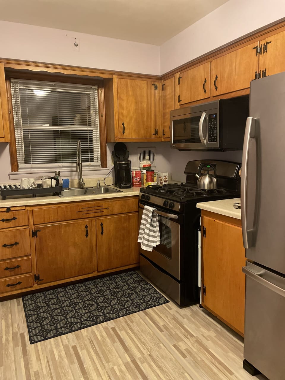 Kitchen with gas stove and large refrigerator.
