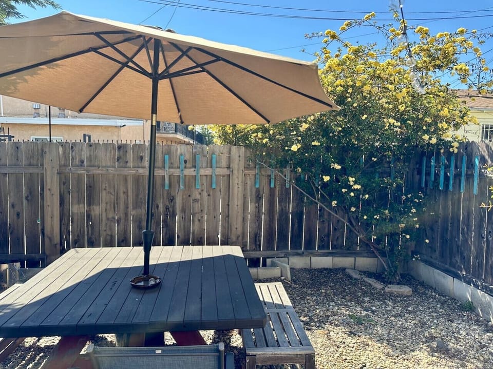 Umbrella-shaded patio table for alfresco meals, with a grill available
