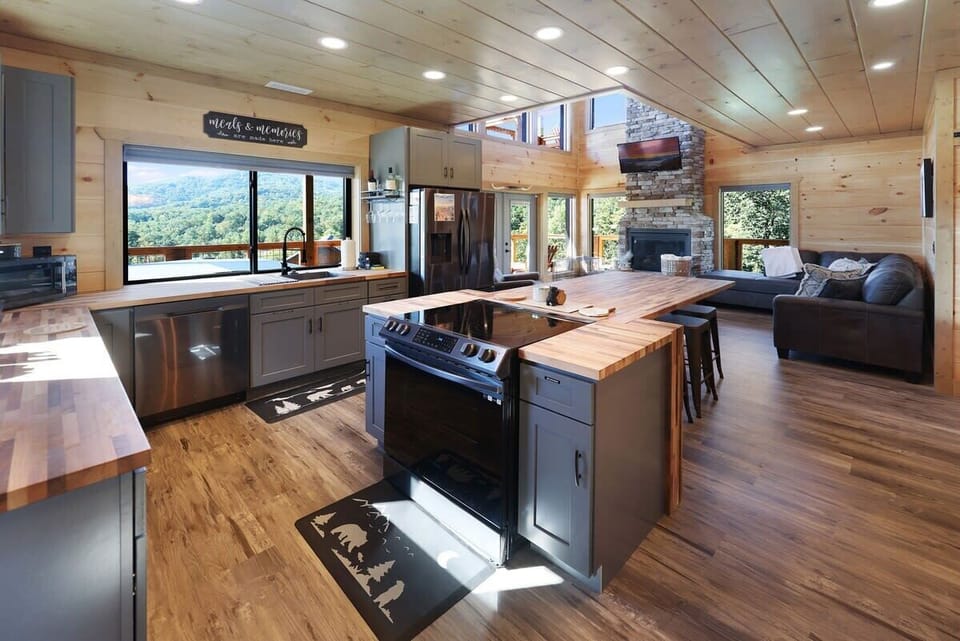 Open kitchen and living area with wood finishes and mountain views.