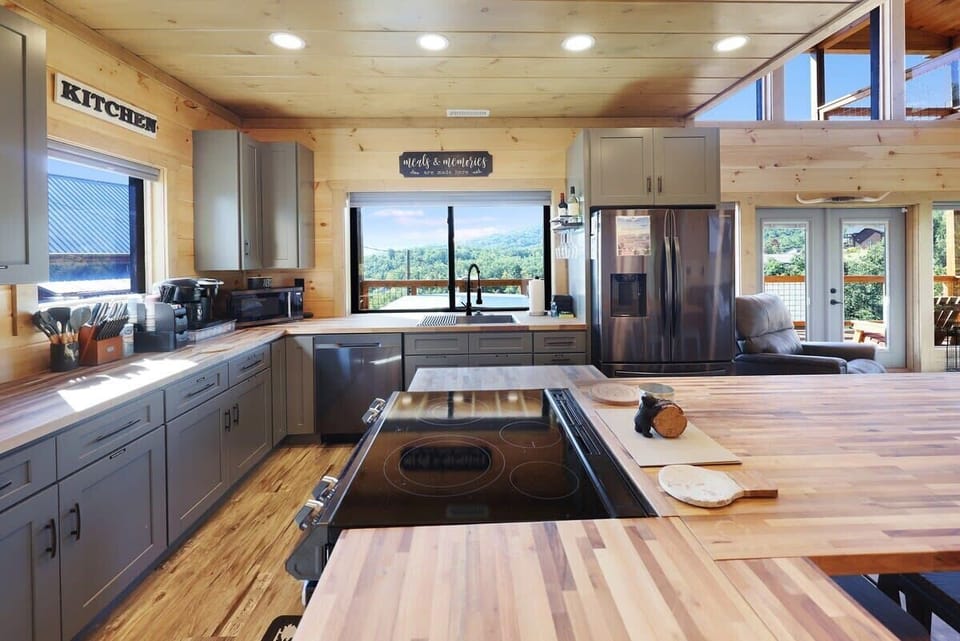 Modern kitchen with wooden countertops and a scenic mountain view through the window