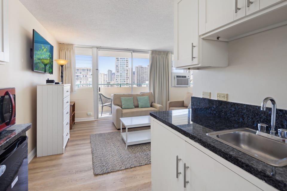 Step into your bright, airy studio where city views meet coastal comfort. Unwind on the cozy sofa, whip up meals in your sleek kitchenette, and step onto your private balcony to soak in the skyline.