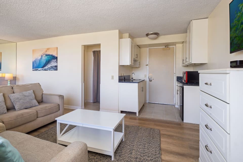 Step into your bright, open-concept space where the living area flows seamlessly into your fully-equipped kitchen. Unwind on the cozy sofa after a day exploring, with everything you need to make meals and feel at home.