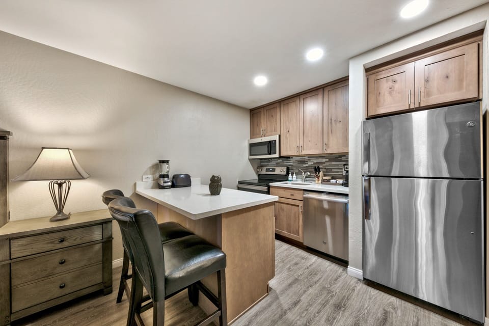 Your fully equipped kitchen awaits with modern appliances, granite countertops, and a breakfast bar where you can enjoy morning coffee.