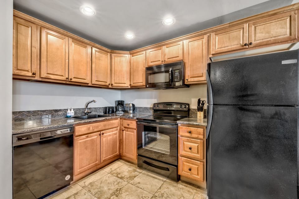 Cook your favorite meals in this fully equipped kitchen with granite counters, warm wood cabinets, and modern appliances.
