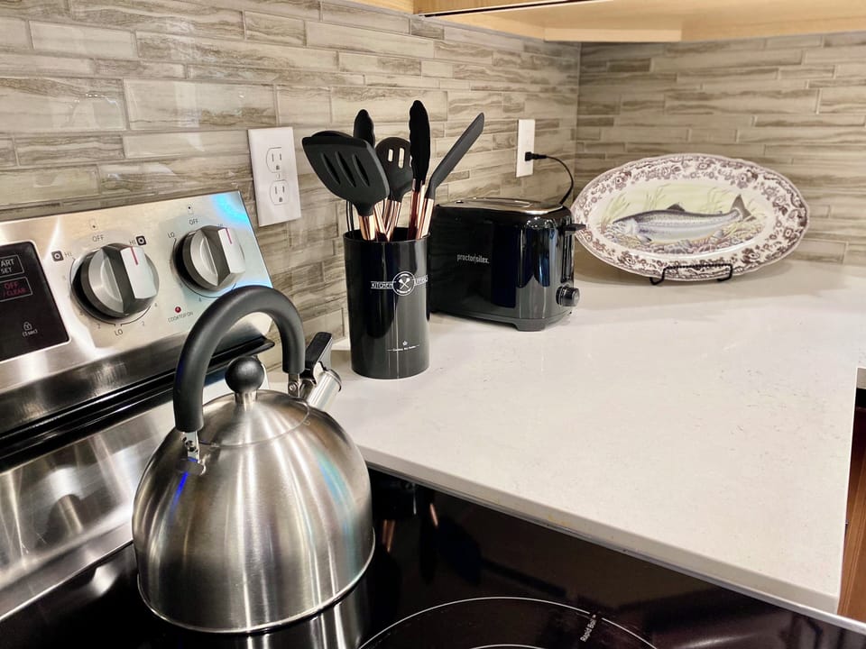 Kitchen with pots/pans, toaster, coffee maker and utensils. 