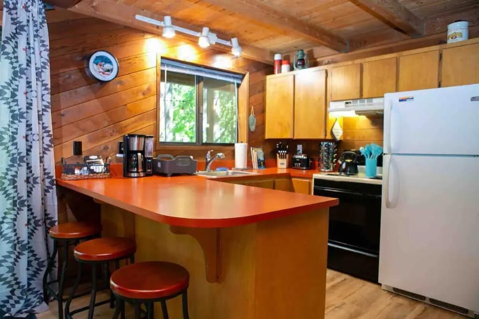 Stocked kitchen with pots, pans, griddle, spices, cooking oil, and utensils.