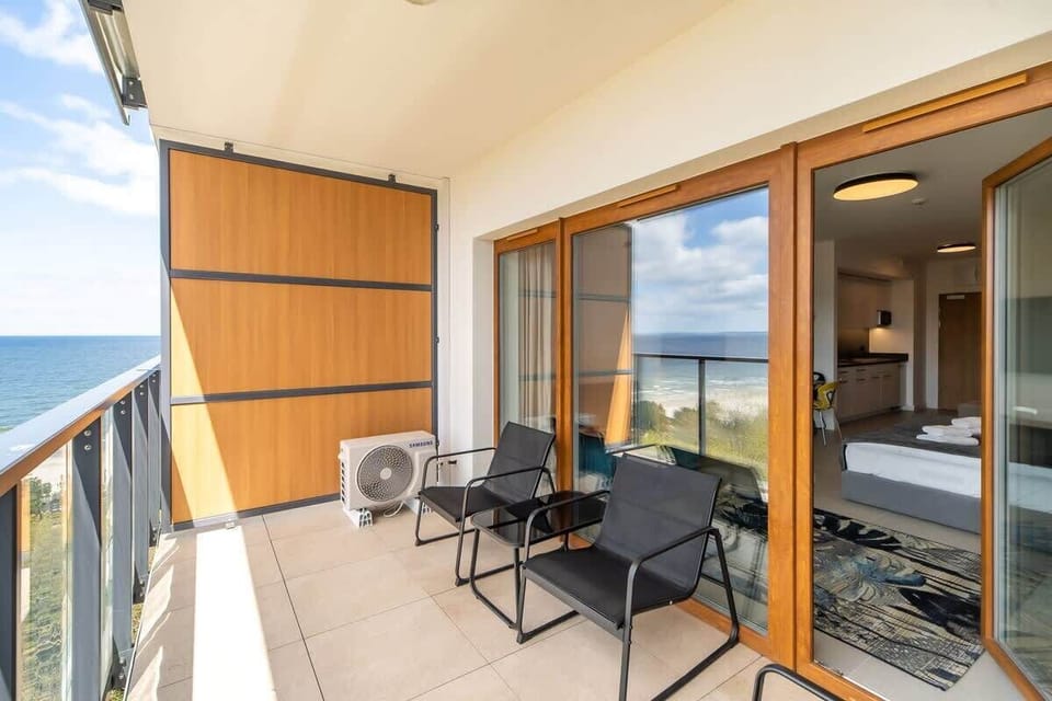 Spacious balcony with outdoor furniture. 